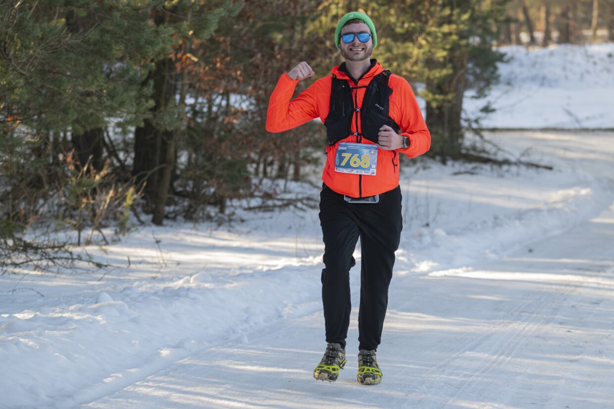 Biegacz uśmiecha się do zdjęcia na trasie Maratonu.